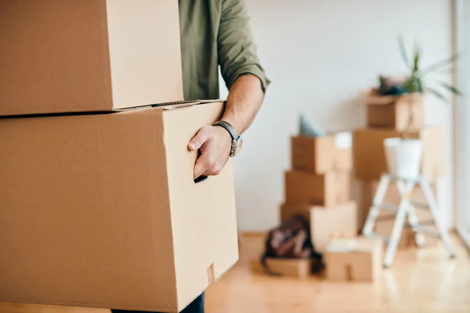 Personne portant des cartons lors d'un déménagement